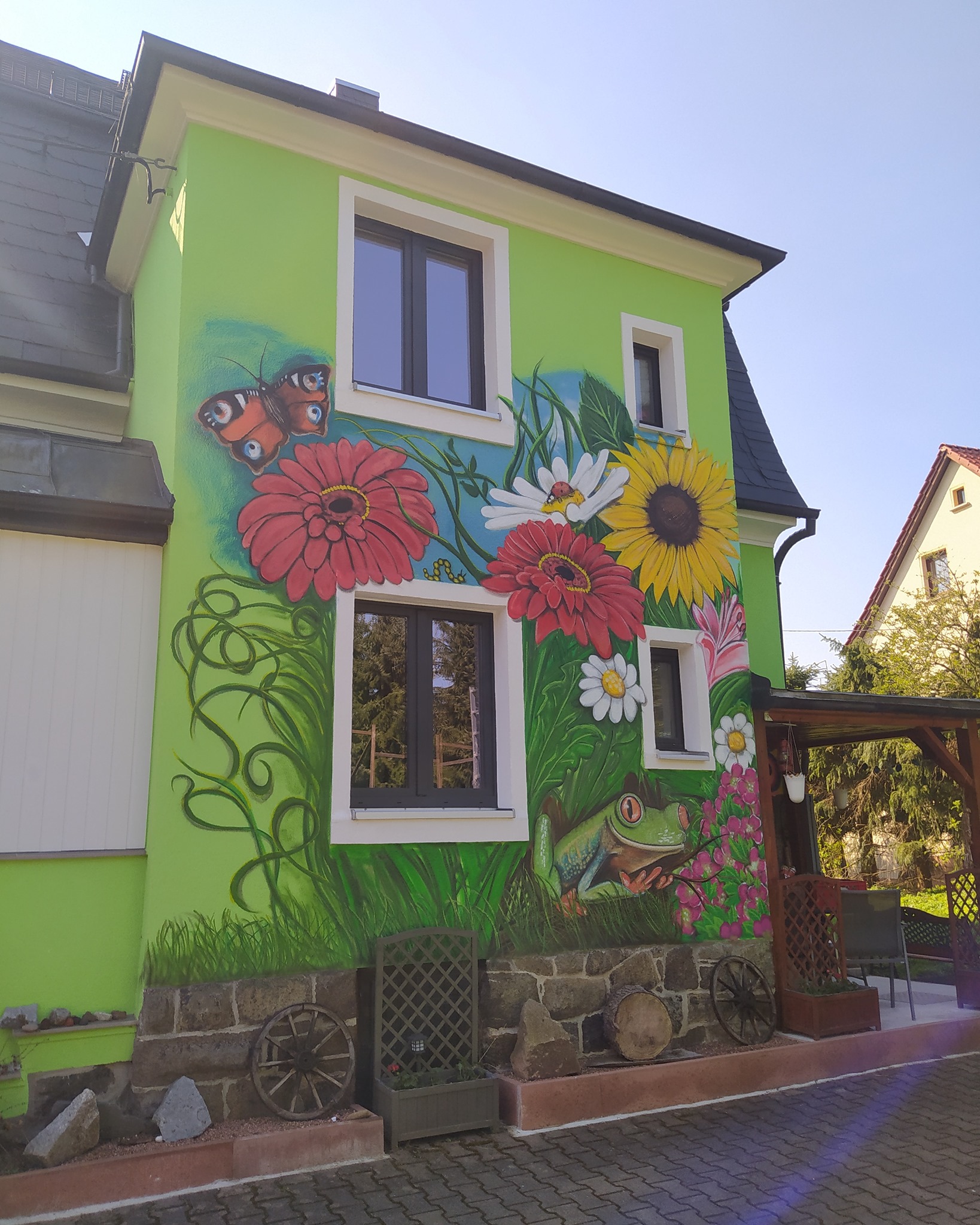 Blumengraffiti an einer Hausfassade